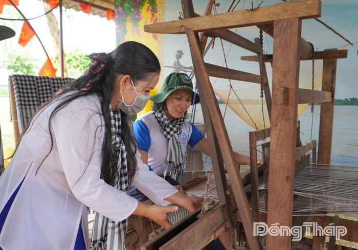 Du khách trực tiếp trải nghiệm nghề dệt khăn choàng.