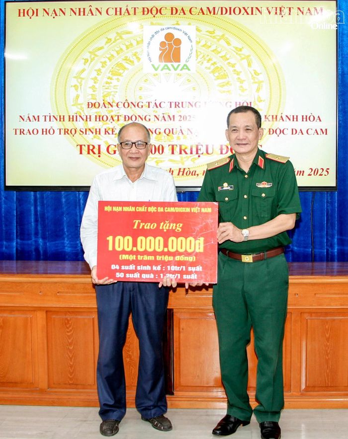 Đại diện Hội Nạn nhân chất độc da cam/dioxin Việt Nam trao bảng tượng trưng kinh phí hỗ trợ cho Hội Nạn nhân chất độc da cam/dioxin tỉnh để trao cho hội viên.