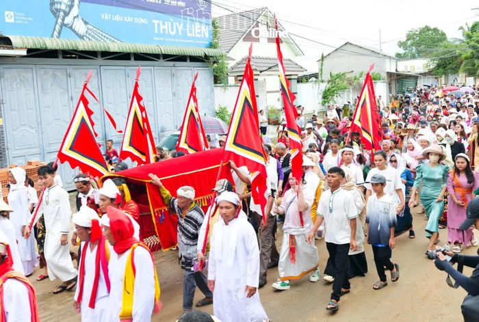 Đông đảo người dân theo sau đoàn rước y trang Pô Inư Nưgar tại thôn Hữu Đức, xã Phước Hữu.