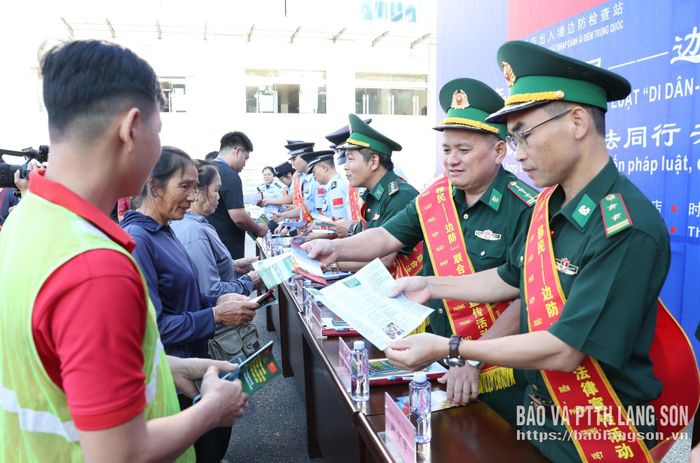 Lực lượng chức năng hai bên phát tờ rơi tuyên truyền pháp luật cho người dân qua lại cửa khẩu