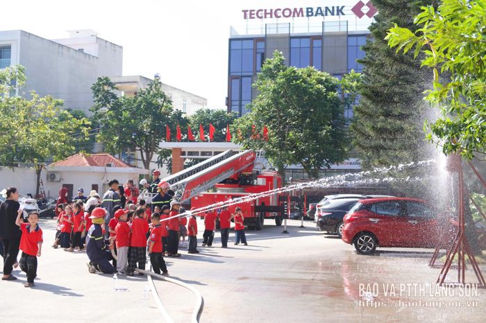 Các học sinh trải nghiệm dùng vòi phun nước chữa cháy