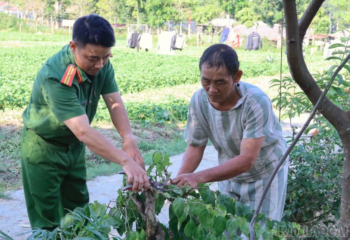Thiếu tá Hoàng Cao Sơn hướng dẫn phạm nhân cắt tỉa cây cảnh.
