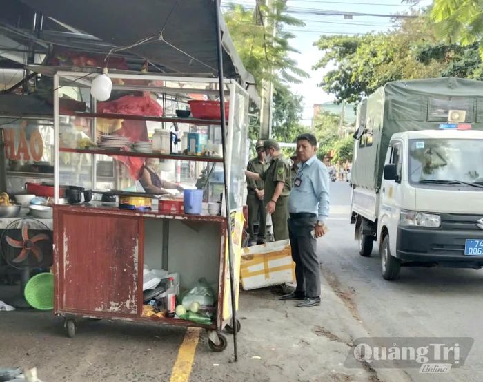 Anh Lý Quang Hào phối hợp với lực lượng chức năng tuyên truyền hộ kinh doanh giữ gìn trật tự vỉa hè, hành lang an toàn giao thông - Ảnh: K.S
