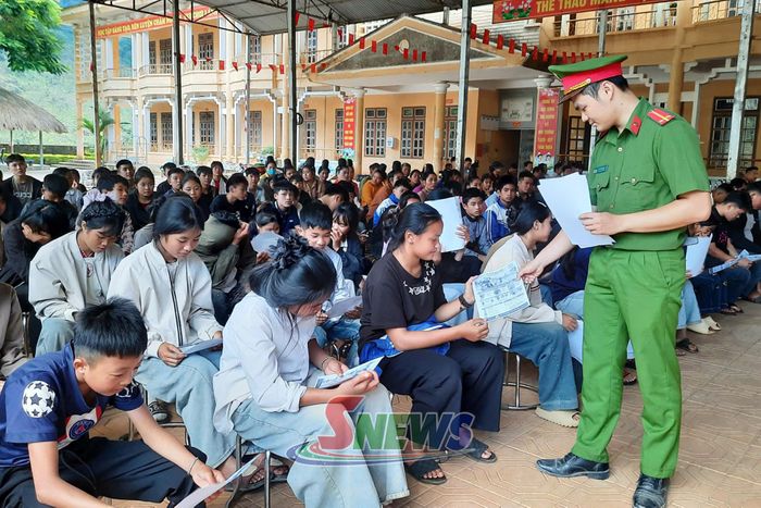 Cán bộ Công an xã phát tờ rơi tuyên truyền pháp luật về trật tự ATGT