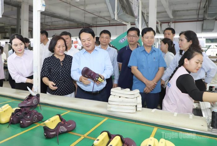 Bí thư Tỉnh uỷ Hầu A Lềnh kiểm tra sản phẩm giày của Công ty TNHH Giày da Phúc Sinh.