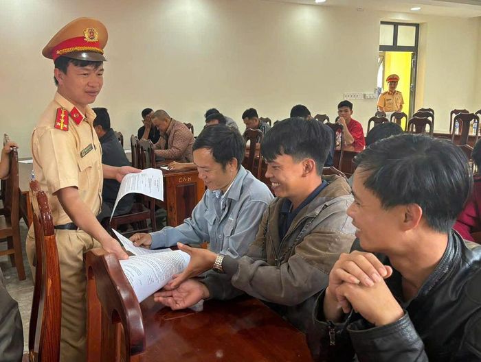 Cảnh sát giao thông hướng dẫn các lái xe kinh doanh vận tải tìm hiểu, chấp hành quy định pháp luật về an toàn giao thông. (Ảnh: CALĐ)