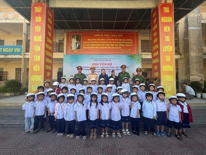 Cán bộ lực lượng Công an cùng giáo viên và học sinh Trường Tiểu học Nam Sơn chụp ảnh lưu niệm tại chương trình tuyên truyền an toàn giao thông.