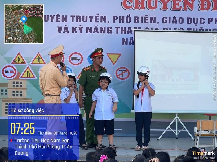 Cán bộ Đội Cảnh sát giao thông đường bộ số 2 trực tiếp hướng dẫn học sinh Trường Tiểu học Nam Sơn cách đội và sử dụng mũ bảo hiểm đúng quy cách.