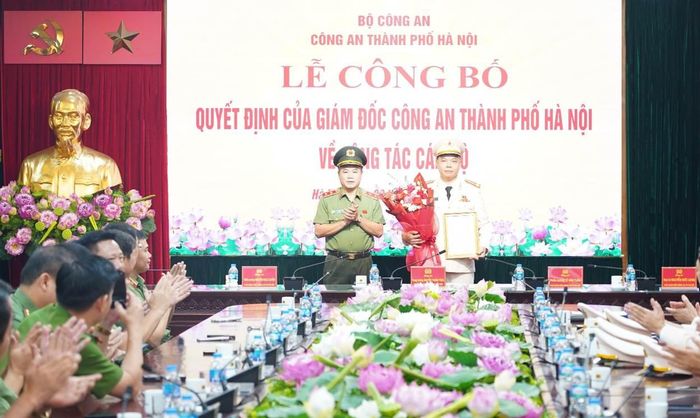 Trung tướng Nguyễn Thanh Tùng - Ủy viên Ban Thường vụ Thành ủy, Bí thư Đảng ủy, Giám đốc CATP trao quyết định và tặng hoa chúc mừng Thượng tá Đỗ Thế Thắng.
