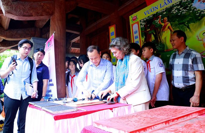 Đồng chí Mai Sơn, Ủy viên Ban Thường vụ Tỉnh ủy, Phó Chủ tịch Thường trực UBND tỉnh Bắc Ninh cùng khách quốc tế trải nghiệm in mộc bản chùa Vĩnh Nghiêm.