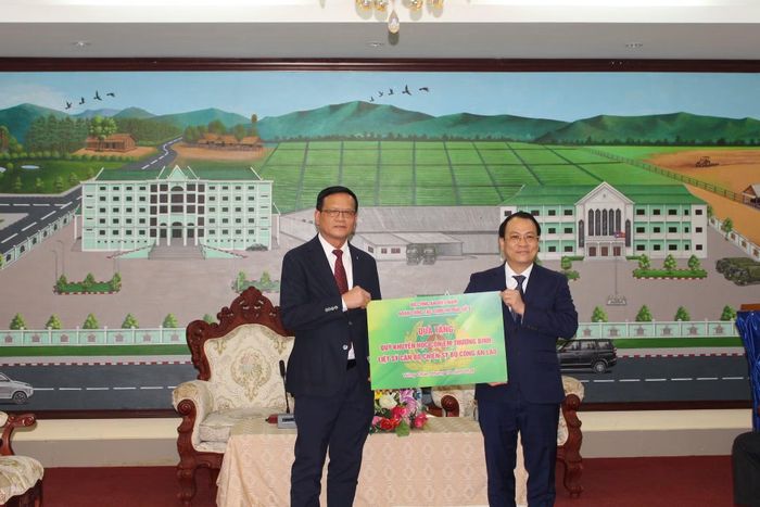 PGS.TS Nguyễn Tiến Quang (bên phải), đại diện Cụm Thi đua số 9, Bộ Công an Việt Nam trao quỹ khuyến học cho con em thương binh, liệt sĩ Công an Lào.