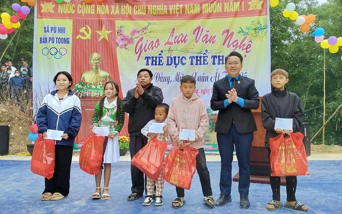 Anh Lâu Văn Phía - Phó bí thư thường trực Đảng ủy xã Trung Lý, tỉnh Thanh Hóa (người thứ 2 từ bên phải sang) trao quà khuyến học cho học sinh. Ảnh nhân vật cung cấp