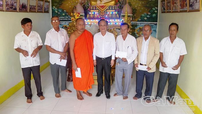 Đồng chí Phạm Văn Thiều tặng quà chúc mừng lễ Sene Dolta đến vị sư trụ trì và các thành viên Ban Quản trị chùa Kim Cấu.