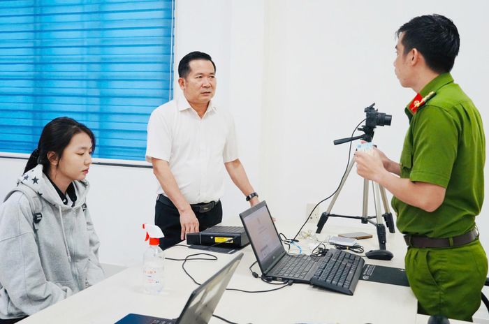 Ông Đinh Văn Nơi thăm hỏi cán bộ công an về việc cấp căn cước cho người dân. (Ảnh: Dung Hoàng).