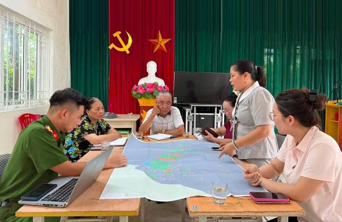 Tổ công tác phường Long Biên hỗ trợ người dân làm sạch dữ liệu đất đai. Ảnh: Thu Phương