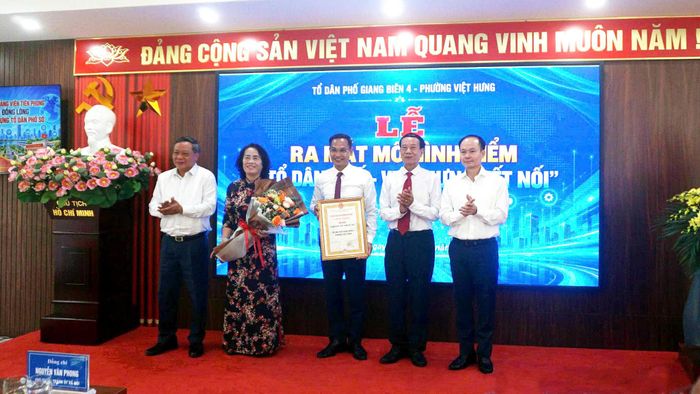 Phó Bí thư Thành ủy Nguyễn Văn Phong và Bí thư Đảng ủy, Chủ tịch HĐND phường Việt Hưng Đường Hoài Nam trao Quyết định công nhận mô hình tới lãnh đạo Tổ dân phố Giang Biên 4. Ảnh: B.Duy
