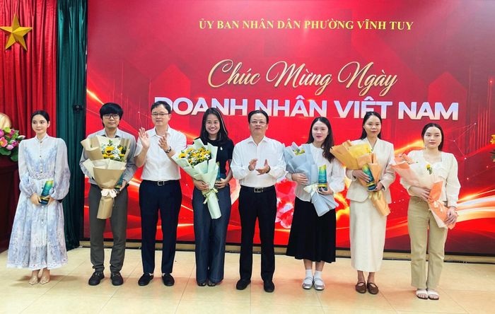 Lãnh đạo phường Vĩnh Tuy tặng hoa chúc mừng đại diện các doanh nghiệp nhân Ngày Doanh nhân Việt Nam. Ảnh: Việt Thắng
