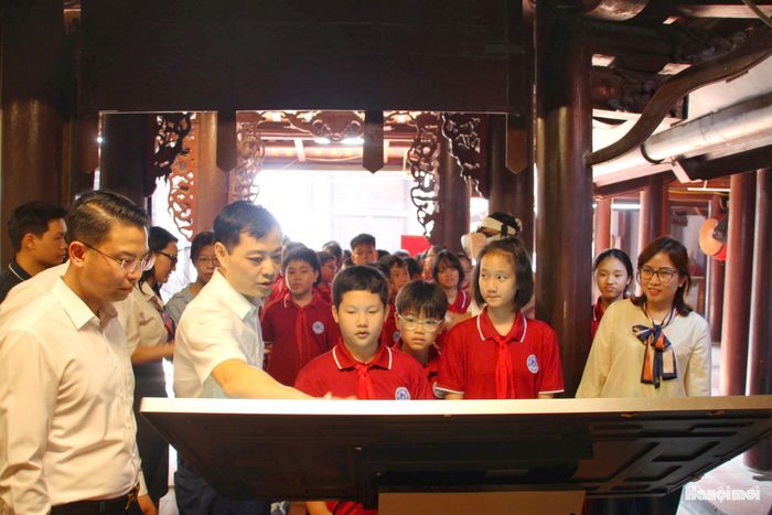 Các đại biểu và học sinh trải nghiệm không gian số hóa hiện vật 3D tại đình Phú Gia. Ảnh: Cao Kỳ