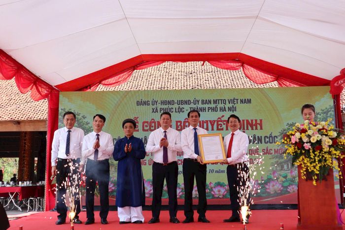 Phó Giám đốc Sở Văn hóa, Thể thao và Du lịch Hà Nội Trần Trung Hiếu trao Quyết định Điểm du lịch Di tích đình Vân Cốc cho xã Phúc Lộc. Ảnh: Nguyễn Mai