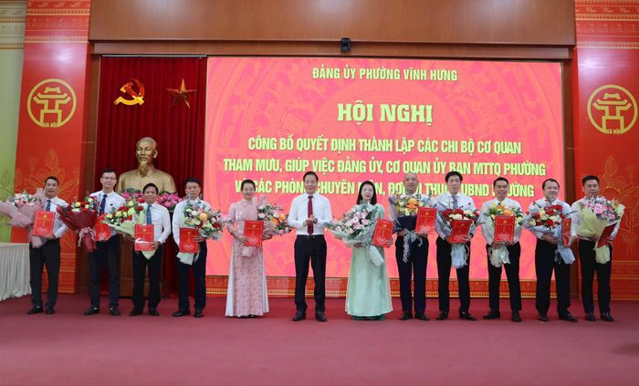 Bí thư Đảng ủy, Chủ tịch HĐND phường Nguyễn Đức Dũng trao quyết định và tặng hoa chúc mừng các chi bộ mới được thành lập. Ảnh: XS