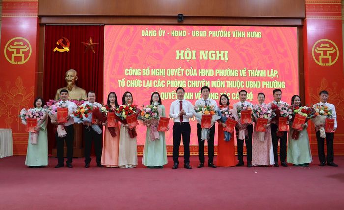 Bí thư Đảng ủy, Chủ tịch HĐND phường Nguyễn Đức Dũng trao quyết định và tặng hoa chúc mừng các cá nhân nhận nhiệm vụ mới. Ảnh: XS