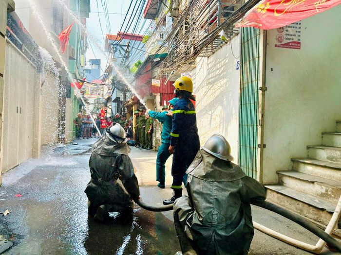 Triển khai đội hình phun nước dập lửa. Ảnh: Trần Oanh.