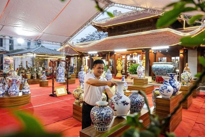 Nghệ nhân Đào Việt Bình bên các sản phẩm gốm sứ Kim Lan. Ảnh: Hội Gốm sứ Kim Lan