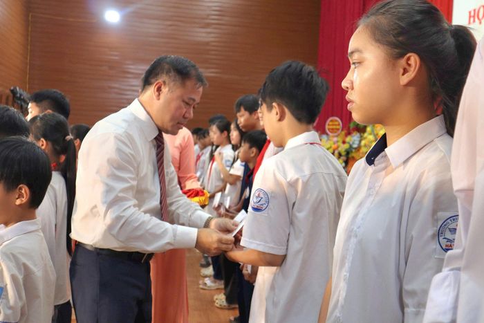 Lãnh đạo xã Hát Môn tặng quà học sinh có hoàn cảnh khó khăn, nỗ lực vươn lên trong học tập. Ảnh: Nguyễn Mai