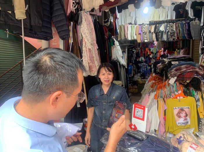 Người dân sử dụng mã QR khi mua sắm tại chợ Vàng. Ảnh: Hoàng Anh
