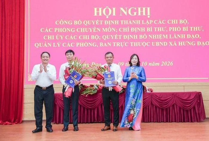 Lãnh đạo xã Hưng Đạo trao quyết định cho Phó Trưởng phòng phụ trách Phòng Nội vụ - Tư pháp và Phó Giám đốc phụ trách Ban Quản lý dự án đầu tư - hạ tầng xã. Ảnh: Minh Anh