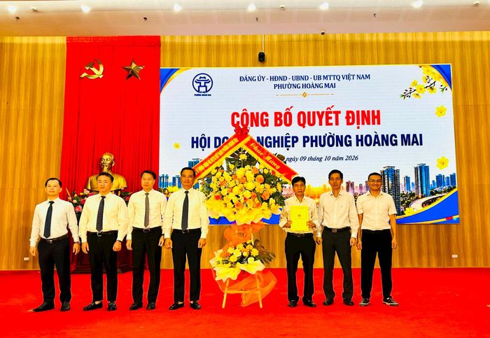 Lãnh đạo phường Hoàng Mai trao quyết định và tặng hoa chúc mừng Ban Chấp hành lâm thời Hội Doanh nghiệp phường Hoàng Mai. Ảnh: Trần Oanh.