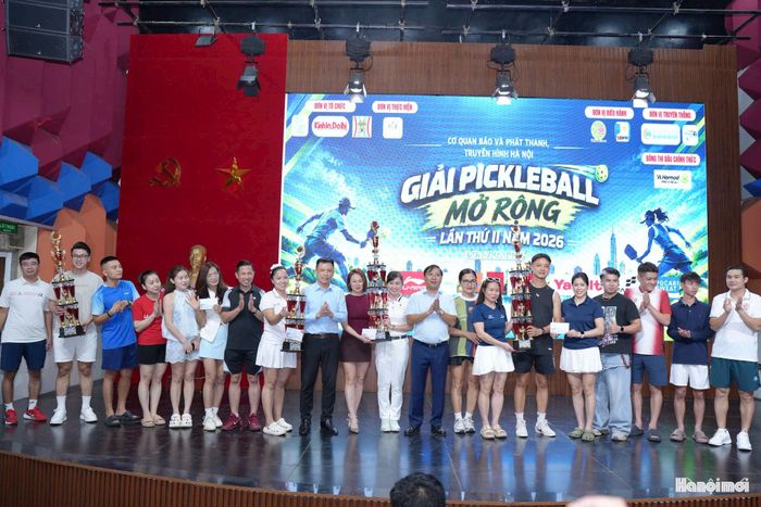 Tổng Giám đốc Cơ quan Báo và Phát thanh, Truyền hình Hà Nội Nguyễn Thanh Liêm và Phó Tổng Giám đốc Nguyễn Thành Lợi trao giải nội dung Đồng đội Nhất, Nhì, Ba cho các đội tham dự. Ảnh: Phạm Mạnh