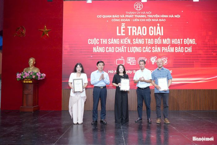Phó Bí thư Đảng ủy, Phó Tổng Giám đốc Thường trực, Thư ký Liên Chi hội Nhà báo Cơ quan Nguyễn Minh Đức; Ủy viên Ban Thường vụ Đảng ủy, Phó Tổng Giám đốc Cơ quan Nguyễn Kim Khiêm trao giải Nhì cho tác giả và nhóm tác giả đoạt giải. Ảnh: Phạm Mạnh