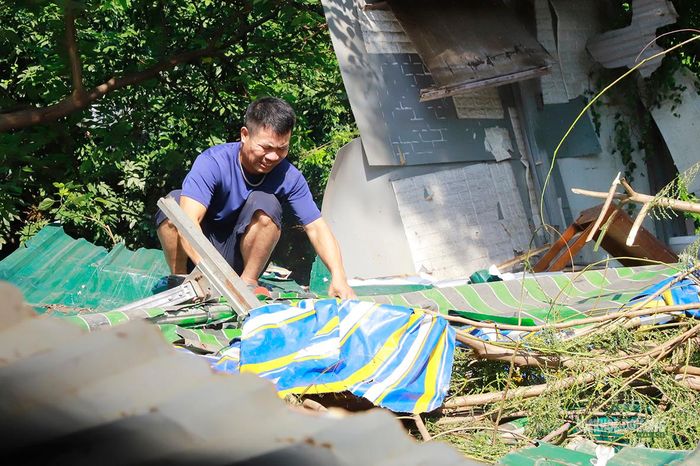 Một người đàn ông thu gom vật liệu còn sót lại sau tháo dỡ. Ảnh: Tuấn Anh