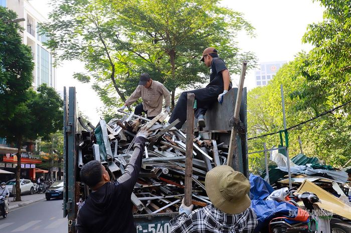 Nhóm công nhân đưa những thanh sắt vừa tháo dỡ lên xe tải. Ảnh: Tuấn Anh
