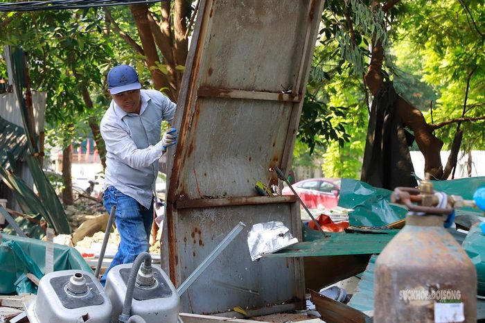Một người đàn ông di chuyển tấm kim loại lớn khỏi khu vực tháo dỡ. Ảnh: Tuấn Anh