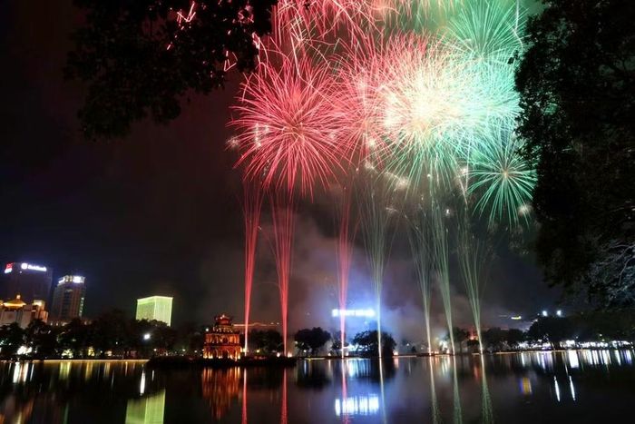 Những chùm pháo hoa tầm thấp xòe rộng như vòng tay ôm trọn lấy không gian cổ kính quanh hồ