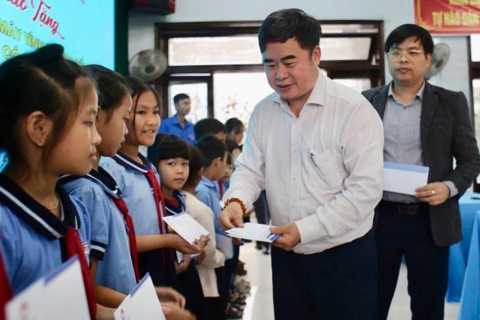  PGS.TS Phạm Minh Tuấn, Chủ tịch Hội Xuất bản Việt Nam, trao quà tặng là sách thiếu niên, nhi đồng. Ảnh: Quốc Anh.