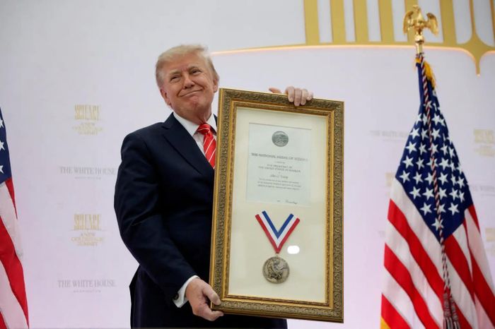  Tổng thống Trump cầm trên tay Huân chương Khoa học Quốc gia năm 1983, giải thưởng được trao cho chú của ông, Tiến sĩ John Trump. Ảnh: Reuters. 
