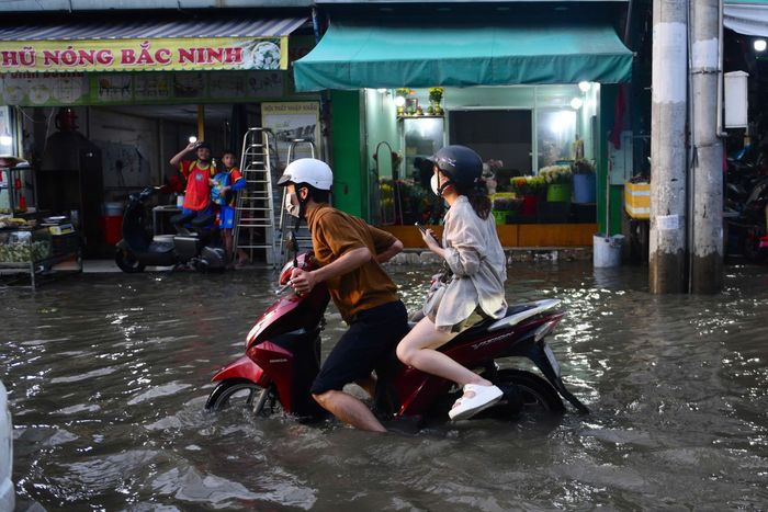 Đến hơn 18h, nước vẫn khá cao. Xe cộ chết máy hàng loạt trước số 150 Phạm Hữu Lầu vì ngập sâu. Ảnh: Duy Hiệu.