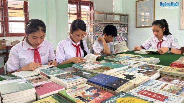  Các em học sinh đọc sách từ tủ sách Đặng Thùy Trâm. 