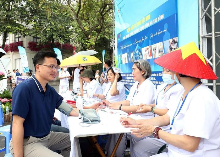 Cán bộ y tế thực hiện đo huyết áp và kiểm tra các chỉ số sức khỏe cơ bản cho người dân trước khi tư vấn