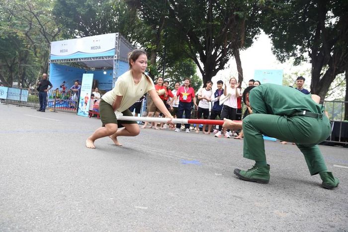 Hai vận động viên đẩy gậy tập trung cao độ, giằng co quyết liệt trong tiếng cổ vũ nồng nhiệt của người dân