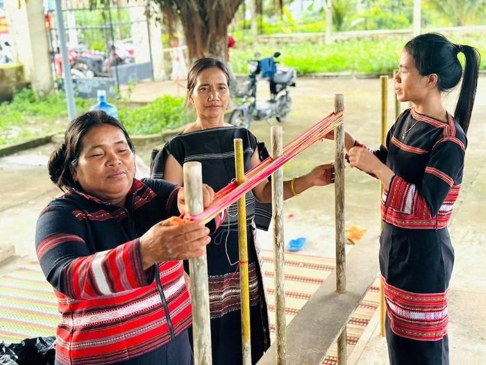 Nghệ nhân hướng dẫn học viên sử dụng khung dệt truyền thống, mắc khung, dăng sợi và thực hành các thao tác cơ bản