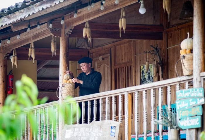Trưởng thôn Sình Dỉ Gai trang trí homestay của gia đình. Ảnh: TTXVN
