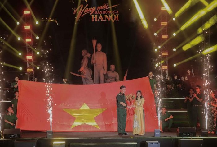 Trung tướng Đào Văn Nhận, Tư lệnh Bộ Tư lệnh Thủ đô Hà Nội, tặng hoa chúc mừng bà Nguyễn Thị Kim Chi, Phó Giám đốc sản xuất Nhà hát Ca múa nhạc Thăng Long