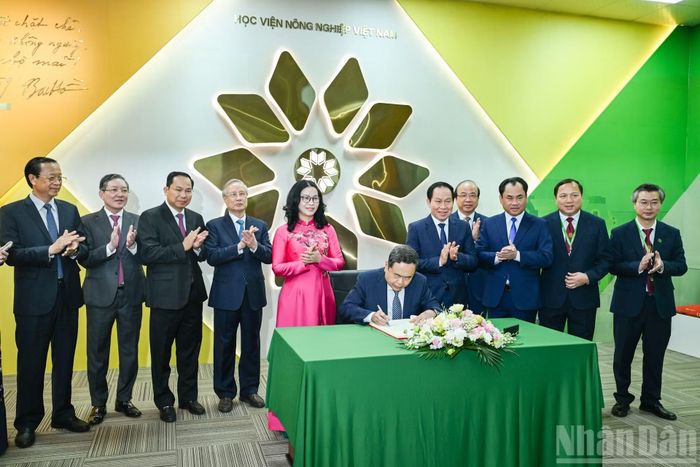 Chủ tịch Quốc hội Trần Thanh Mẫn ghi sổ vàng tại phòng truyền thống Học viện Nông nghiệp Việt Nam. (Ảnh: DUY LINH)
