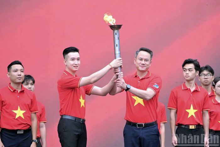 Đại diện tuổi trẻ Thủ đô, Phó Bí thư Đoàn Thanh niên, Chủ tịch Hội Liên hiệp thanh niên thành phố Hà Nội Đào Đức Việt (thứ 2 từ trái sang) đã đón ngọn đuốc. Đây là nghi thức thể hiện sự tiếp nối giữa các thế hệ, truyền thống lịch sử và khát vọng của tuổi trẻ hôm nay. (Ảnh: LINH PHAN)
