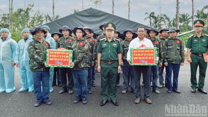 Thượng tướng Lê Quang Minh, Phó Chủ nhiệm Tổng cục Chính trị Quân đội nhân dân Việt Nam tặng quà động viên lực lượng thực hiện nhiệm vụ lấy mẫu hài cốt liệt sĩ chưa xác định được thông tin tại Nghĩa trang Liệt sĩ Tiền Giang, tỉnh Đồng Tháp. (Ảnh: CHÍ PHÚC)