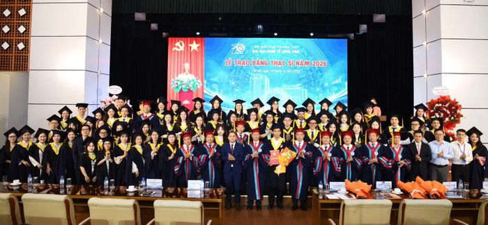 Các tân thạc sĩ chụp ảnh lưu niệm cùng lãnh đạo, giảng viên nhà trường. (Ảnh: TUẤN ANH)